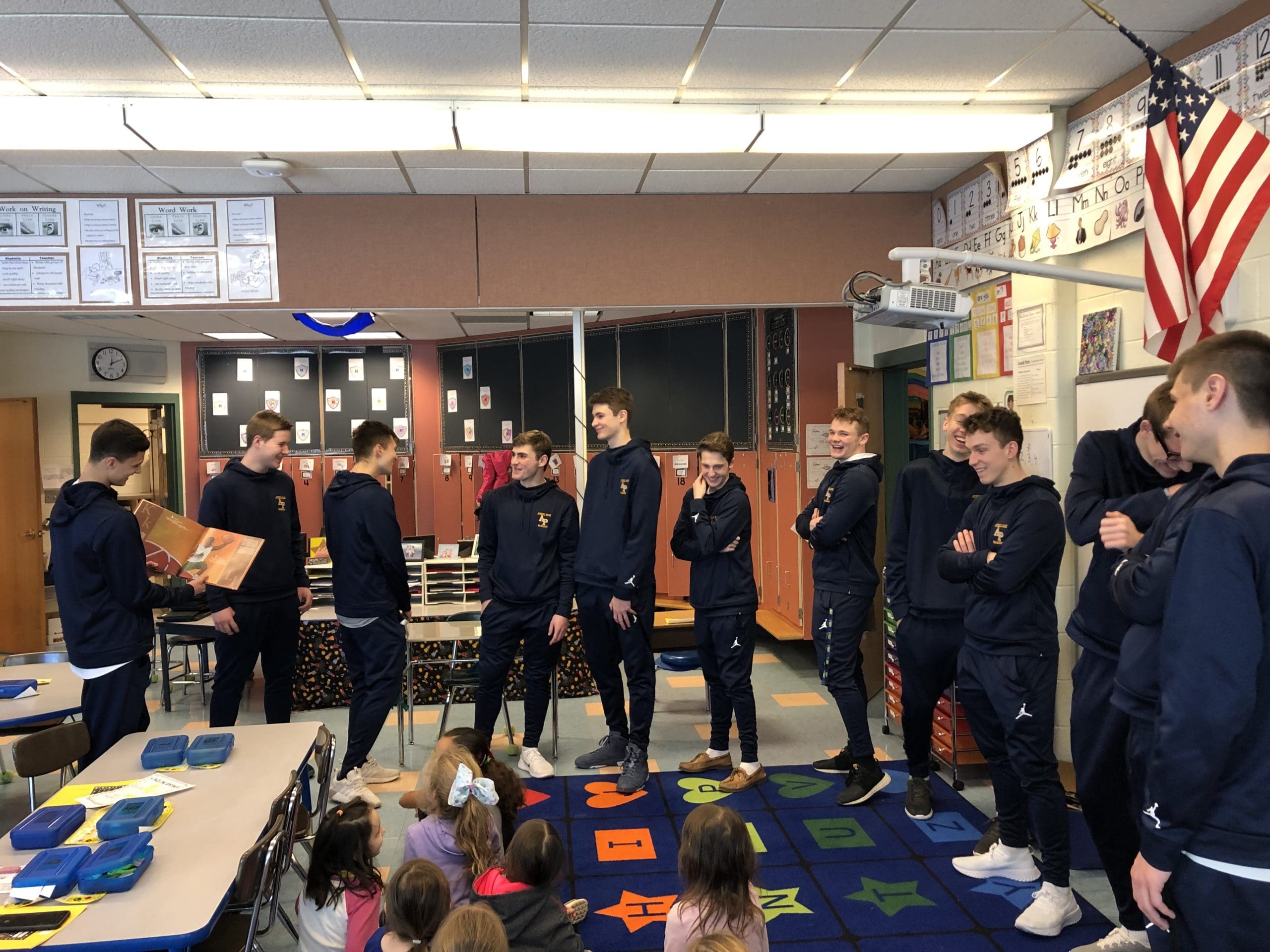 Boys basketball reading to first graders