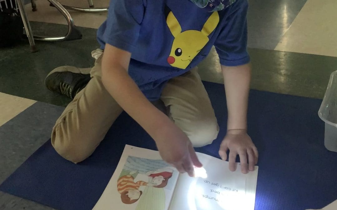 Kindergarten Students Work on Reading With Flashlight Friday